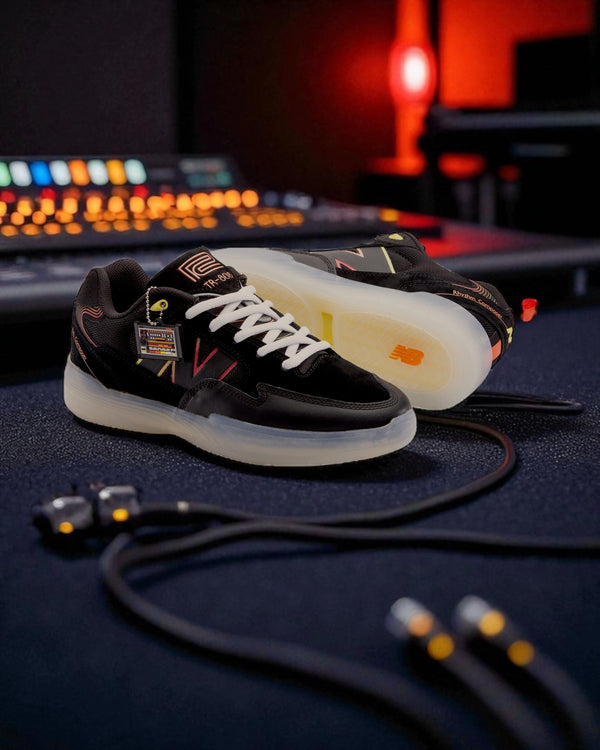 New Balance Numeric 808 Lite x Roland TR-808 sneaker in black suede with translucent sole, photographed in a music studio with synth cables and warm lighting.